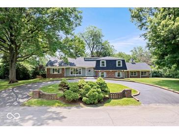 Charming home featuring a circular driveway, lush landscaping, and mature trees at 6337 Cardinal Ln, Indianapolis, IN 46220
