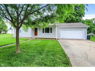 Charming single-story home features a well-manicured lawn, attached garage, and inviting front porch at 6616 S Cross St, Pendleton, IN 46064