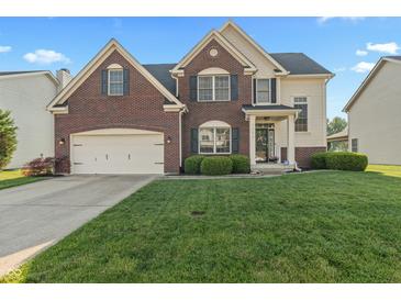 Charming two-story home with brick and siding, featuring a well-manicured lawn and attached two-car garage at 7356 Woodington Pl, Indianapolis, IN 46259