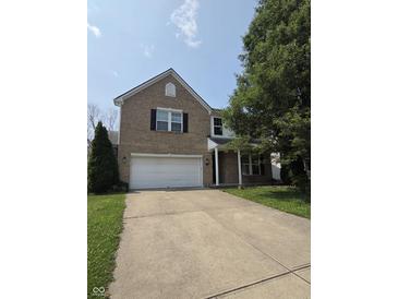 Charming two-story brick home with a two-car garage and landscaped front yard at 10523 Dark Star Dr, Indianapolis, IN 46234