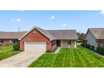 Charming brick home with a well-manicured lawn and attached two-car garage at 10938 E Mount Vernon N Trl, Indianapolis, IN 46229