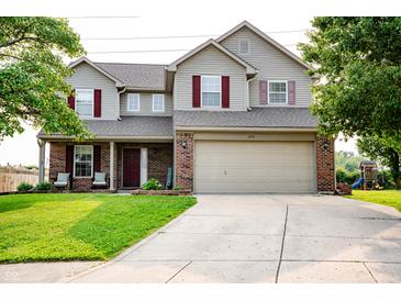 Charming two-story home with a well-manicured lawn, brick accents, and a two-car garage at 1242 Flatrock Dr, Anderson, IN 46013