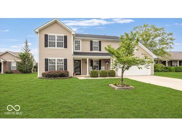 Charming two-story home featuring a well-manicured lawn, attached garage, and a welcoming front porch at 12845 Touchdown Dr, Fishers, IN 46037