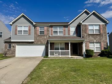 Charming two-story home with brick and gray siding, complemented by a well-manicured lawn at 1442 Bank Pl, Indianapolis, IN 46231