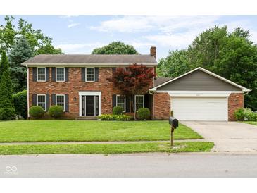 Charming brick home featuring a two-car garage and a well-maintained front yard with mature trees at 3439 Eden Park Dr, Carmel, IN 46033