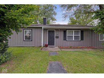 Charming single-story home with gray siding, a black front door, and a well-maintained front yard at 3509 N Wittfield St, Indianapolis, IN 46235