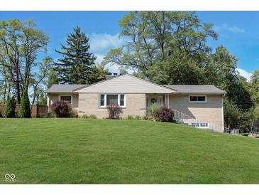 Charming brick ranch home with a lush green lawn and mature trees, offering a picturesque curb appeal at 3740 Cheviot Pl, Indianapolis, IN 46205