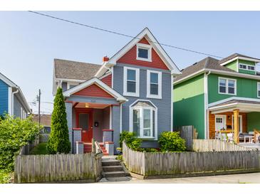 Charming two-story home featuring a colorful exterior, well-maintained lawn, and inviting front porch at 525 Orange St, Indianapolis, IN 46203