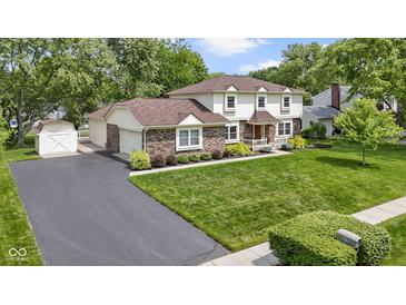 Charming two-story home with brick accents, lush lawn, and attached two car garage at 59 Sycamore Dr, Carmel, IN 46033