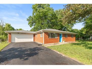 Charming single-story brick home with a vibrant blue front door and attached two-car garage at 7139 Buick Dr, Indianapolis, IN 46214