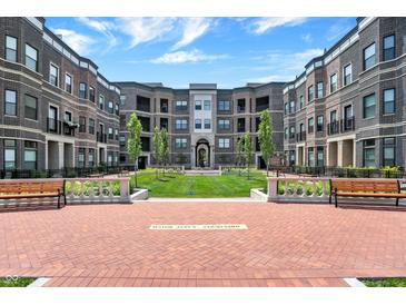Beautiful courtyard featuring well-manicured lawns, benches and walkways surrounded by brick apartment buildings at 920 Veterans Way # 204, Carmel, IN 46032