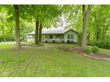 Charming one-story home with a welcoming front porch and lush, mature trees in a peaceful, wooded setting at 10808 Greenbriar Dr, Fishers, IN 46037