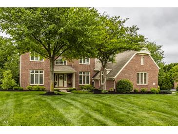 Lovely two-story brick home featuring manicured lawn and mature trees in a peaceful neighborhood setting at 11875 Durbin Dr, Carmel, IN 46032
