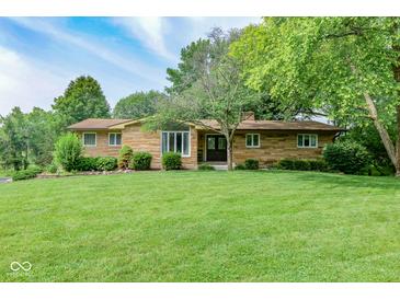 Charming single-story home with stone facade and a well-maintained lawn and mature trees at 138 Plaza Chica St, Greenwood, IN 46143