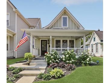 Charming home featuring a welcoming front porch, decorative plants, and an American flag at 1623 Hoyt Ave, Indianapolis, IN 46203