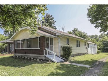 Quaint home featuring a screened-in porch, cream siding and a detached garage at 2245 N Ritter Ave, Indianapolis, IN 46218