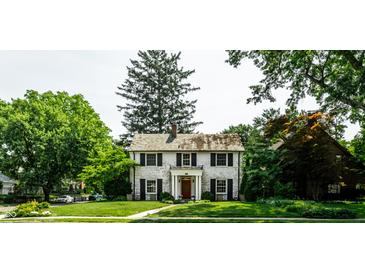 Charming two-story home with a brick facade, manicured lawn, and mature trees at 5261 N Pennsylvania St, Indianapolis, IN 46220