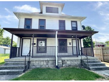 Two-story home featuring a covered front porch and vinyl siding for a classic look at 613 N Tacoma Ave, Indianapolis, IN 46201