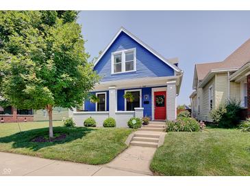 Charming blue home with a red door, green lawn, and inviting curb appeal at 712 Orange St, Indianapolis, IN 46203