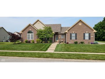 Charming brick home featuring a well-manicured lawn, mature landscaping, and inviting front entrance at 8028 Meadow Bend Ln, Indianapolis, IN 46259