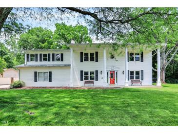 Charming two-story home with a large front yard, white siding and a bright red front door at 1000 Leisure Ln, Greenwood, IN 46142