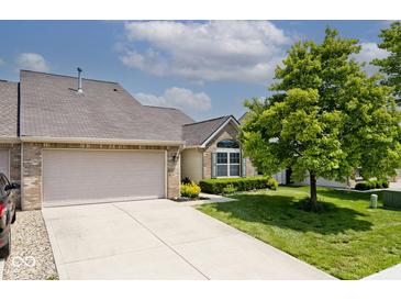 Charming home featuring a large garage, well-manicured lawn, mature tree, and neutral tones at 10668 Whippoorwill Ln, Indianapolis, IN 46231