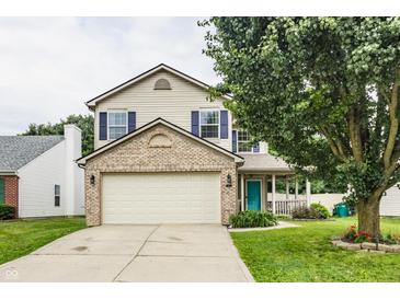 Charming two-story home featuring a brick-accented facade, attached garage, and inviting covered porch at 1112 Halifax Ct, Indianapolis, IN 46231