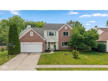 Charming two-story brick and siding home with a well-manicured lawn and inviting front entrance at 14492 Cotswold Ln, Carmel, IN 46033
