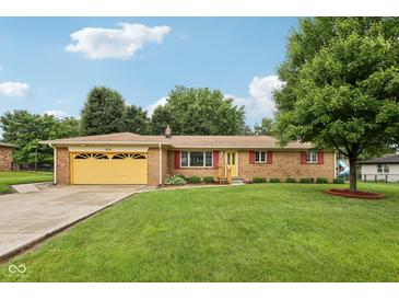 Charming single-story brick home with well-maintained lawn and vibrant yellow garage door at 230 Love Ave, Greenwood, IN 46142