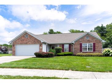 Charming brick home featuring manicured landscaping, an attached garage and tasteful maroon window shutters at 413 Blue Spring Dr, Indianapolis, IN 46239