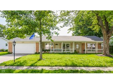 Charming ranch-style home featuring an attached garage, a front porch, and mature landscaping at 48 Wilson Dr, Carmel, IN 46032