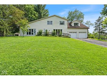 Charming home with a well-manicured lawn, an attached two-car garage, and a beautiful yard with mature trees at 8435 Hilltop Ln, Martinsville, IN 46151