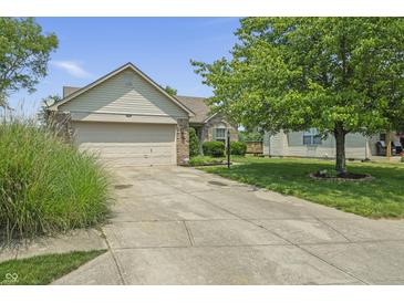 Single-Gathering home with two-car garage, brick accents, manicured lawn and long driveway leading up to the house at 8526 Country Meadows Dr, Indianapolis, IN 46234