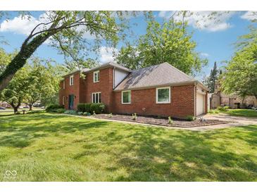 Brick two-story home featuring a spacious lawn, attached garage and driveway at 9256 Colgate St, Indianapolis, IN 46268