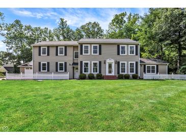 Inviting home with a well-manicured lawn, classic shutters, and surrounded by mature trees at 9650 Copley Dr, Carmel, IN 46290