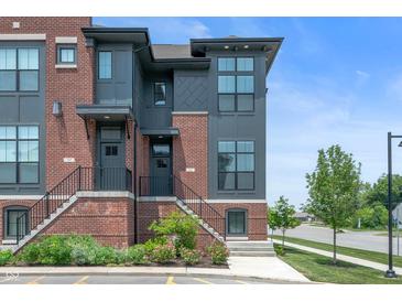 Modern townhome featuring brick and gray siding, enhanced by landscaped front entrances at 205 Poplar St, Westfield, IN 46074