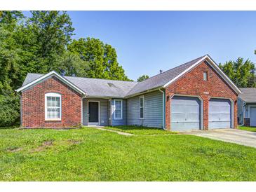 Charming single-story home featuring a brick facade, attached two-car garage, and well-maintained lawn at 3816 Cologne Ct, Indianapolis, IN 46228