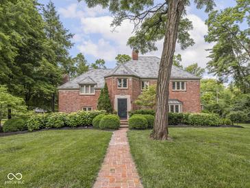 Charming two-story brick home featuring mature trees and professional landscaping along the front yard and walkway at 1207 Pickwick Pl, Indianapolis, IN 46208