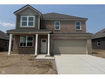Two-story brick home featuring a two-car garage, covered entry, and well-maintained landscaping at 1326 Foxtail Ln, Greenwood, IN 46143