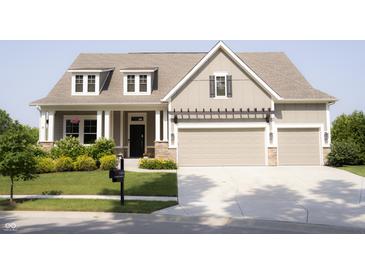 Charming two-story home with a manicured lawn, pergola-covered garage, and inviting front porch at 13820 Woodside Hollow Dr, Carmel, IN 46032