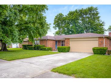 Charming brick ranch home with a well-maintained front yard, mature trees, and a two-car garage at 3235 Flintwood Dr, Columbus, IN 47203