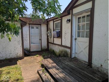 View of exterior side of house, showing multiple doors and peeling paint at 489 W Sumner Ave, Martinsville, IN 46151
