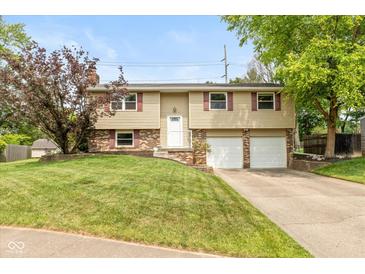 Charming two-story home features a manicured front lawn and attached two car garage at 5802 Rymark Ct, Indianapolis, IN 46250