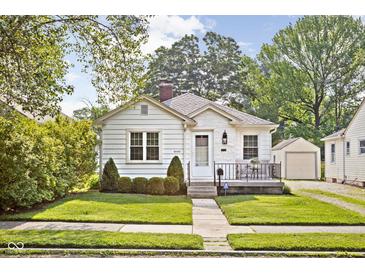 Charming home featuring a well-kept lawn, inviting front porch, and beautiful, traditional architectural details at 6045 Crittenden Ave, Indianapolis, IN 46220