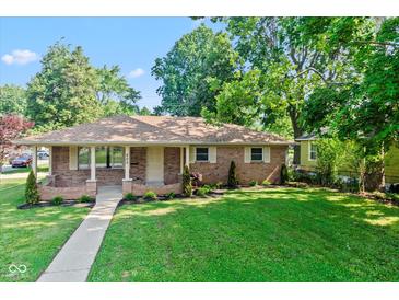 Charming brick ranch home with a well-manicured lawn and inviting walkway at 802 Lawrence Ave, Indianapolis, IN 46227