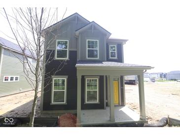 Charming two-story home with a covered porch and a yellow front door at 9516 Bauhaus Way, Indianapolis, IN 46240
