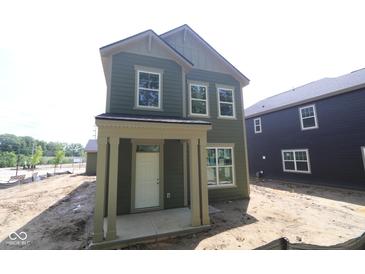 Two-story home featuring a covered porch, double-hung windows, and stylish green siding at 9520 Bauhaus Way, Indianapolis, IN 46240