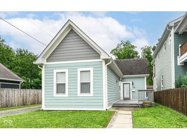 Charming home featuring light-blue wood siding, a front porch, and a well-maintained lawn at 1221 Cottage Ave, Indianapolis, IN 46203
