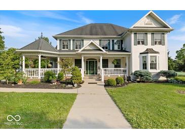 Charming two-story home with a welcoming porch, manicured lawn and landscaped garden beds at 14301 W County Road 300 S, Daleville, IN 47334