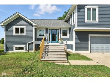 Charming gray two-story home with a blue front door and wooden steps at 17138 Joliet Rd, Westfield, IN 46074